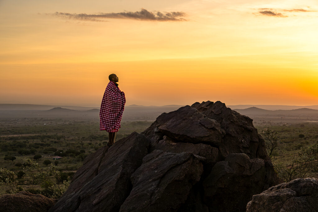 Levé de soleil sur les collines de Maji Moto, photographie d'une silhouette d'un guerrier Masai